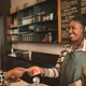 Customer smiling and handing card to cafe cashier